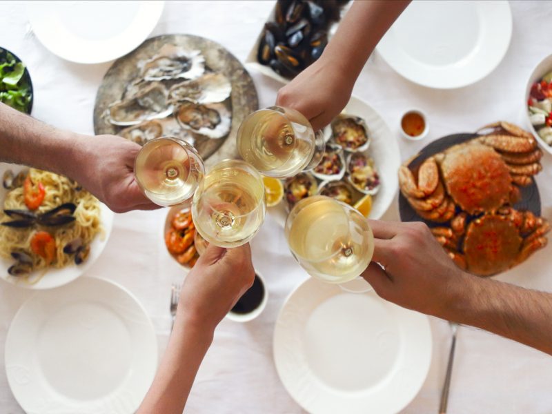 People fine dining seafood and white wine on the table